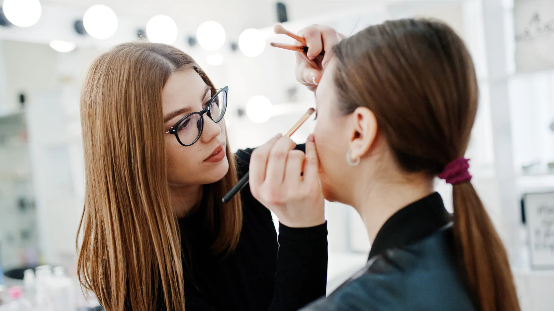 Makeup artist applying professional makeup to a client at the salon