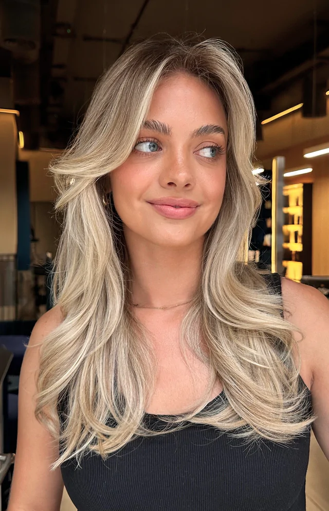 Młoda kobieta o blond włosach patrzy lekko w bok.